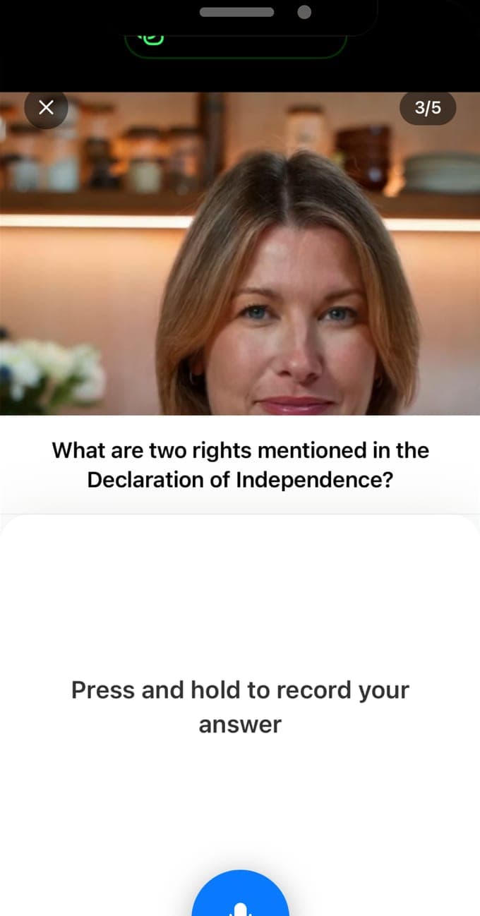 La entrevista por voz de USCIS Interview Practice, pregunta 3 de 5: la entrevistadora en video pregunta en inglés qué dos derechos menciona la Declaración de Independencia, sobre un botón de micrófono que se mantiene pulsado para grabar la respuesta